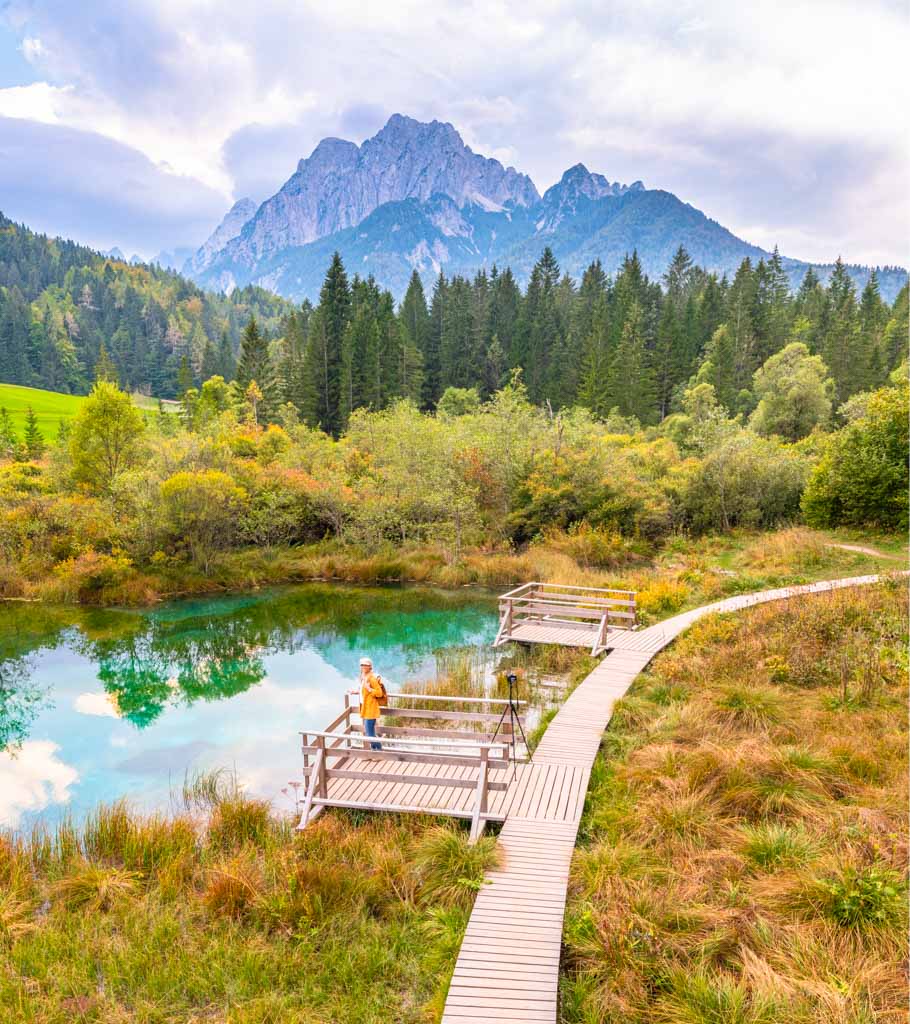 Frau steht an einem tuerkisblauen See in Slowenien