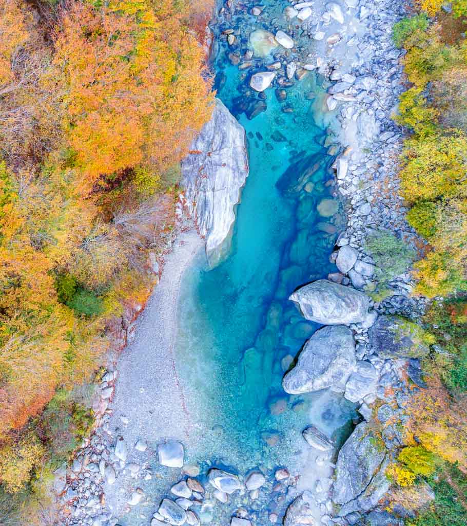 Drohnenaufnahme von einer Herbstnatur und einem blauen Fluss