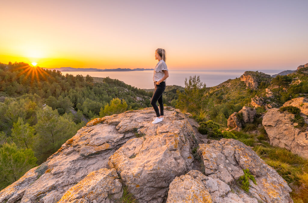 Frau blickt auf einem Felsen in die Ferne