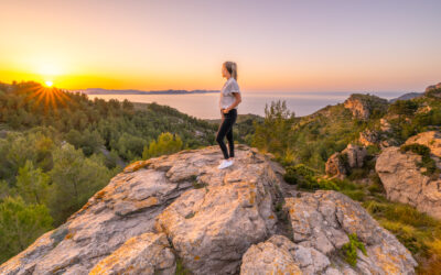 Frau blickt auf einem Felsen in die Ferne