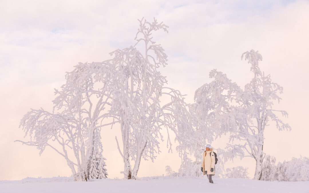 Frau steht in einer schneebedeckten Landschaft